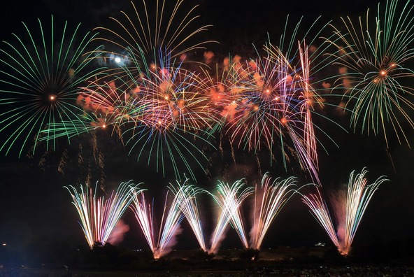 大空に打ち上がる花火が海を美しく照らします