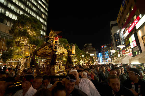 都心のきらびやかなオフィスビル群を背景に、町会神輿2基と氷川山車「猩々」が巡行します