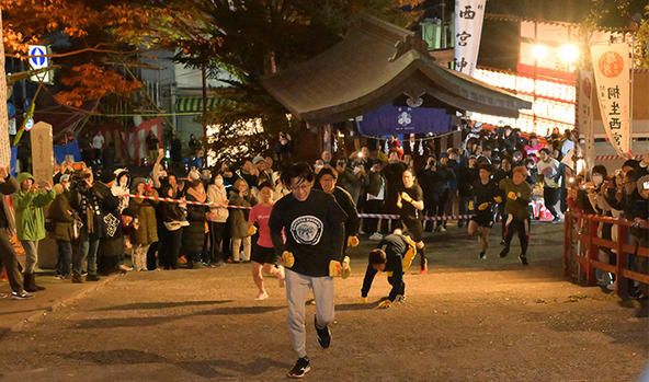 夜明け前の境内を駆け抜ける参拝者たち