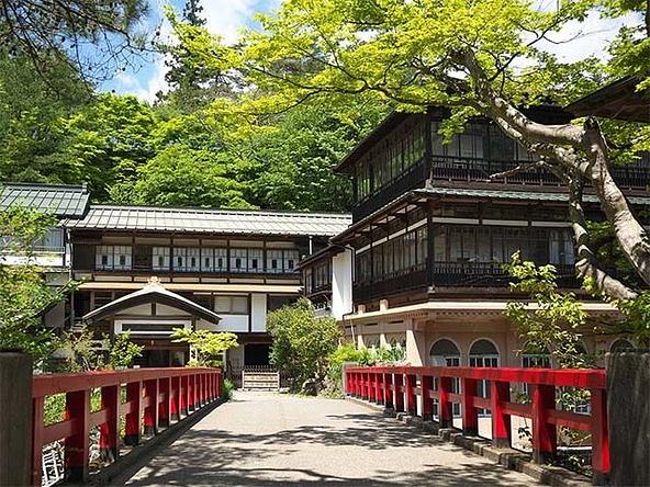赤い橋の奥に建つ本館は、現存するなかではもっとも古い木造建築の湯宿とされています
