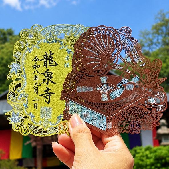秋限定切り絵御朱印『秋音-紅葉-』。童謡「紅葉」の楽譜と色づく紅葉をホログラム箔で表現したデザイン
