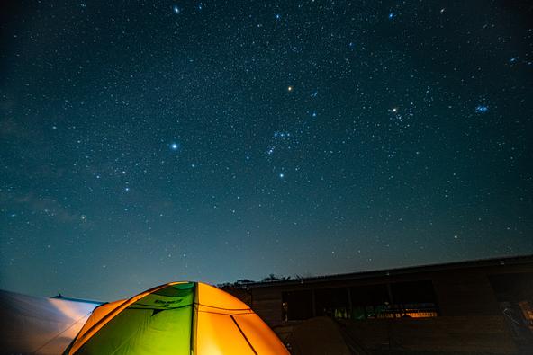 美星町の夜空とキャンプサイトを写した一枚(画像提供:zodiac_yosuke / PIXTA)