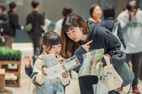 過去の村まつりで、会場を巡りながら楽しむ親子の様子