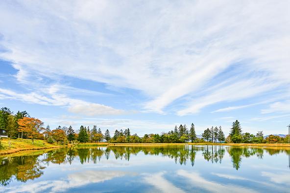 秋の茶臼山湖と、湖面に映る色づいた木々(画像提供:kouyunosa / PIXTA)