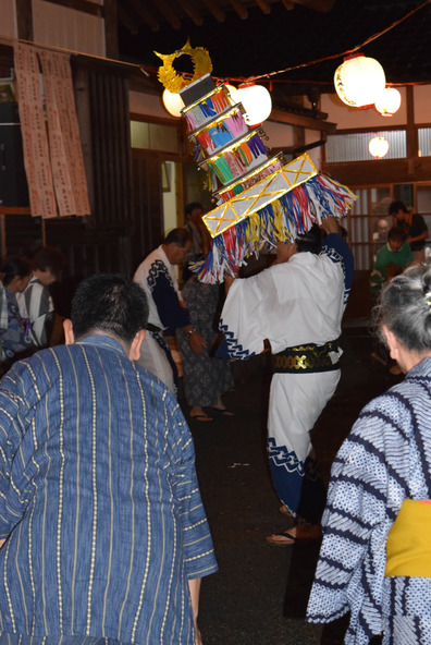 飾り灯籠を頭上にかざした踊り手たち