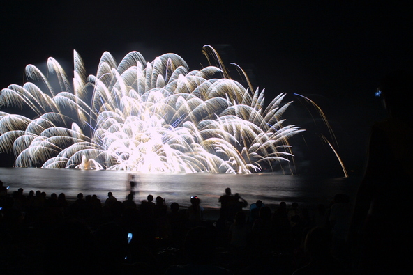 会場いっぱいに屋台が立ち並ぶなか、美しい花火が次々と打ちあがります