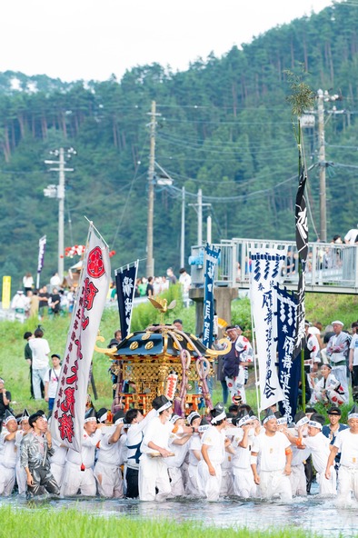 神輿とともに川を渡る姿は迫力満点！