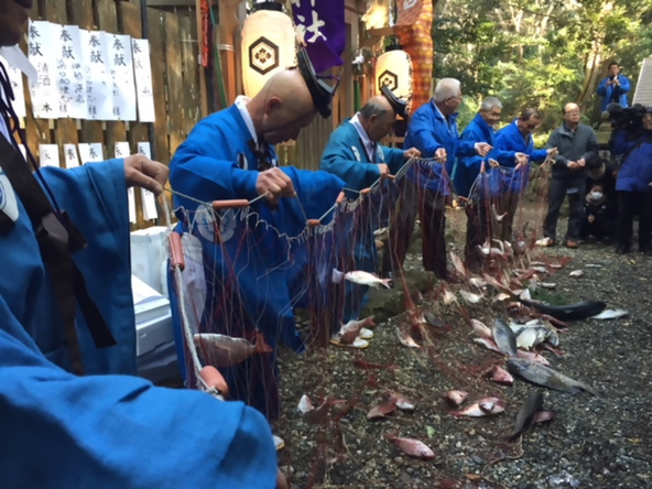 網に魚を投げ入れ一年の漁獲に感謝