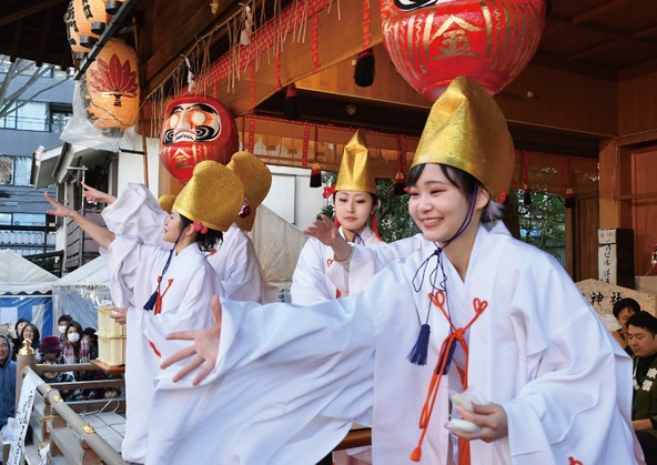 神楽殿から餅を撒く福娘たち