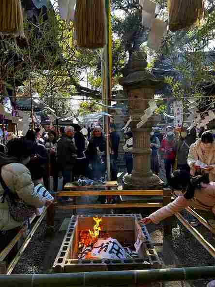 参列者が順に、使い終えた筆や鉛筆、書初めを火に入れます