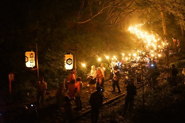 たいまつの火で参道を照らしながら行列が進む光景は圧巻！