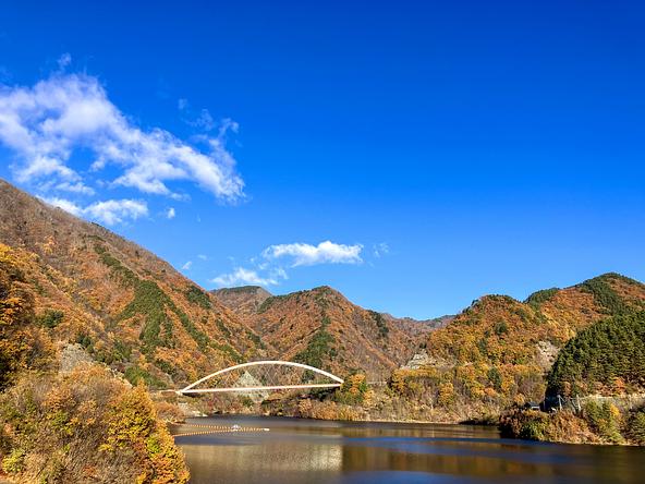 紅葉に彩られた「みずがき湖」と鹿鳴峡大橋（画像提供：Kazzy39 / PIXTA）